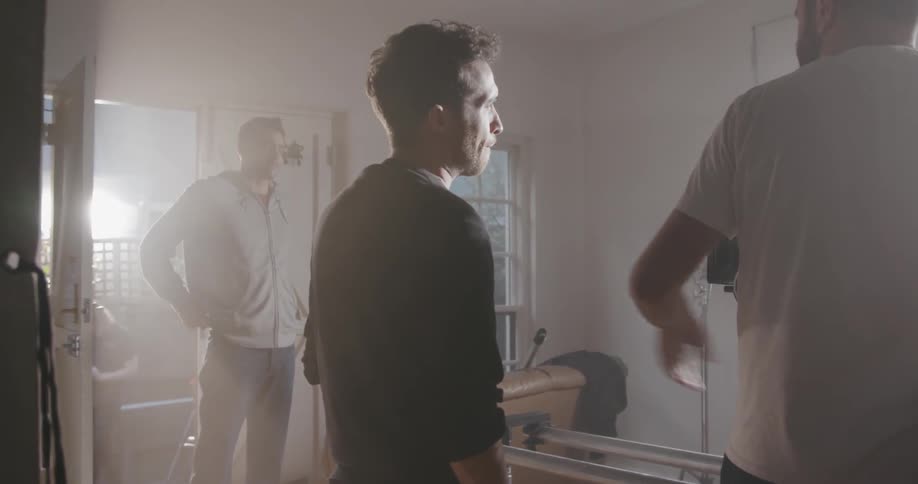 Men stand in a room talking and giving instruction