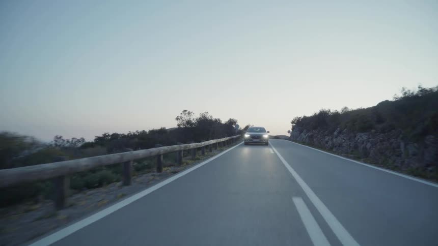 Car travels down a highway near the trees
