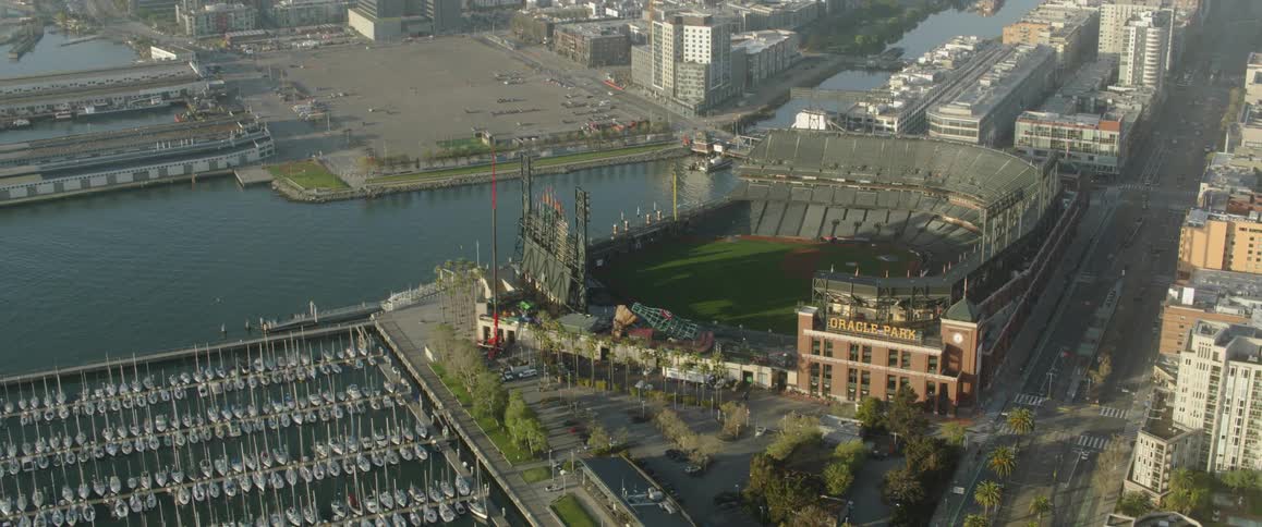 Large building next to a body of water with many boats parked in rows