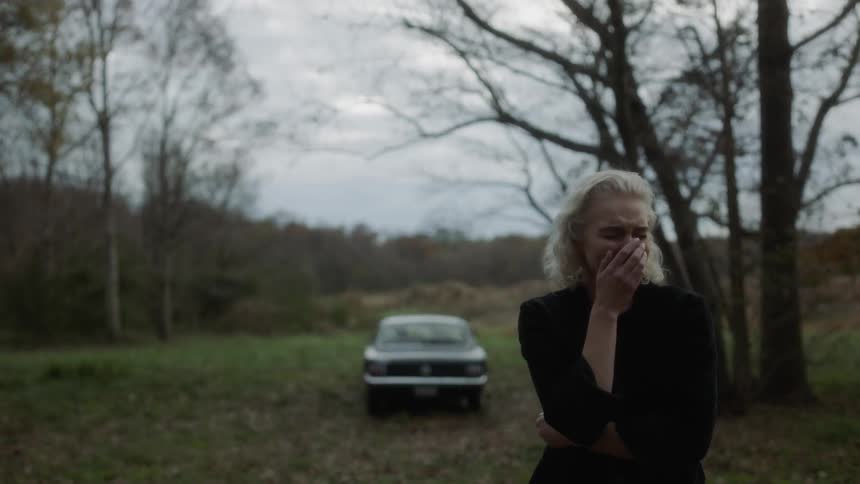 Woman cries in the woods on a cloudy day