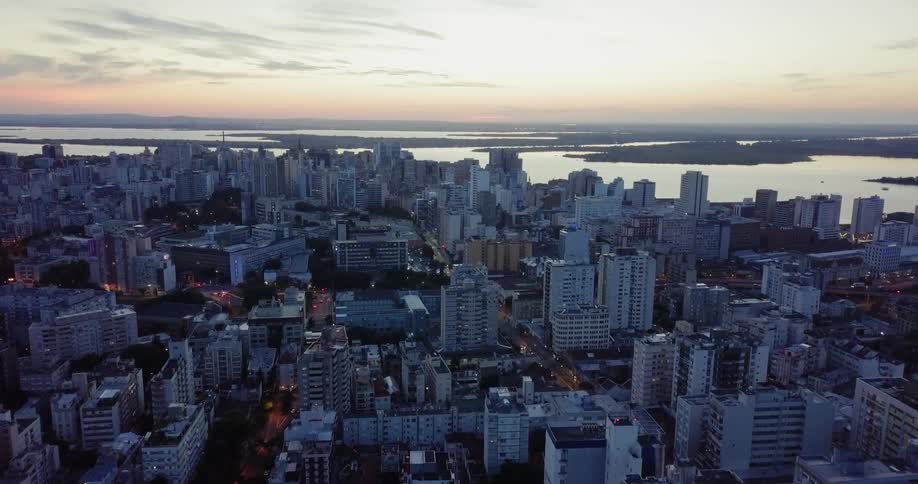 Rooftops and buildings of a coastal city at sunset