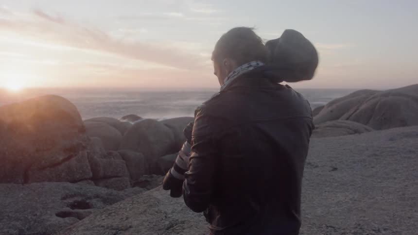 Man takes a photo with a camera that has a long zoom lens