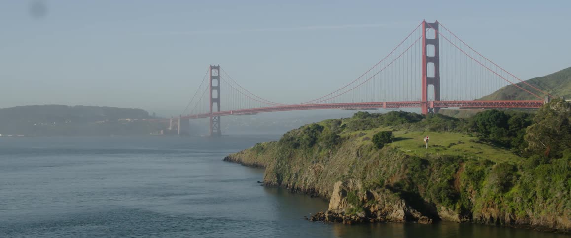The long red bridge is covered with fog