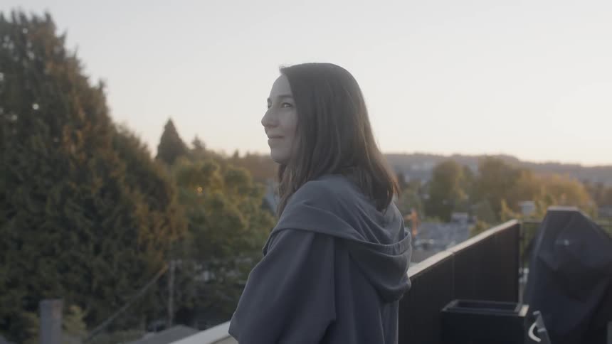 A woman stands on the rough smiling