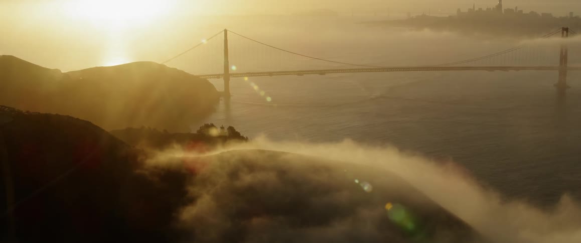 The hills by the bridge are covered with heavy fog