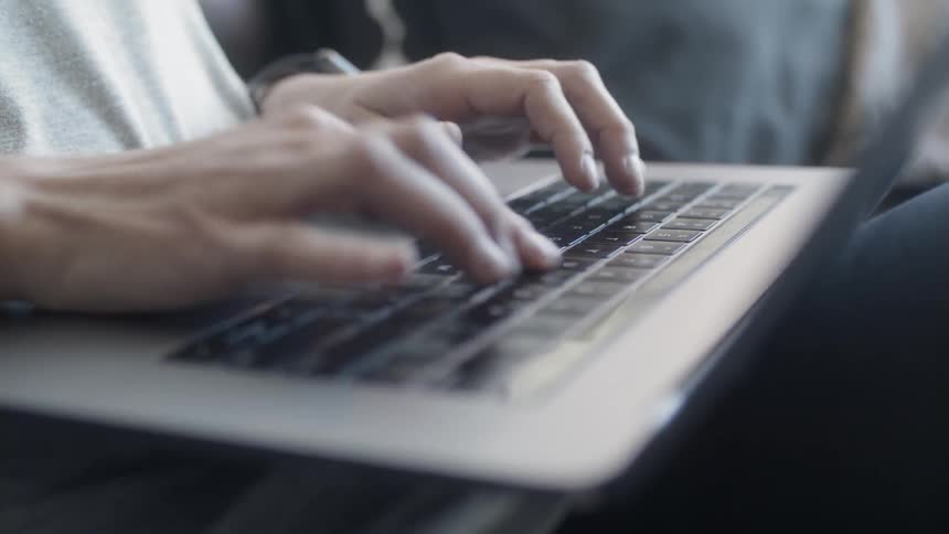 Person types on a laptop
