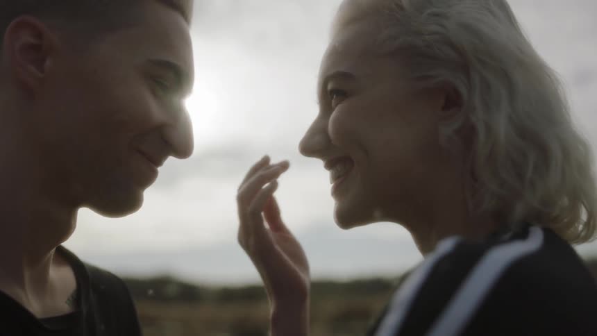 A man and woman smile at each other