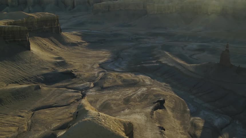 Shadows fall over hilly desert landscape on a sunny day