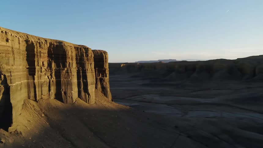 Tall cliffs in a desert at sunset