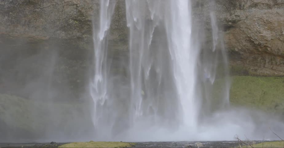 Water falls from above and splashes into the lake below