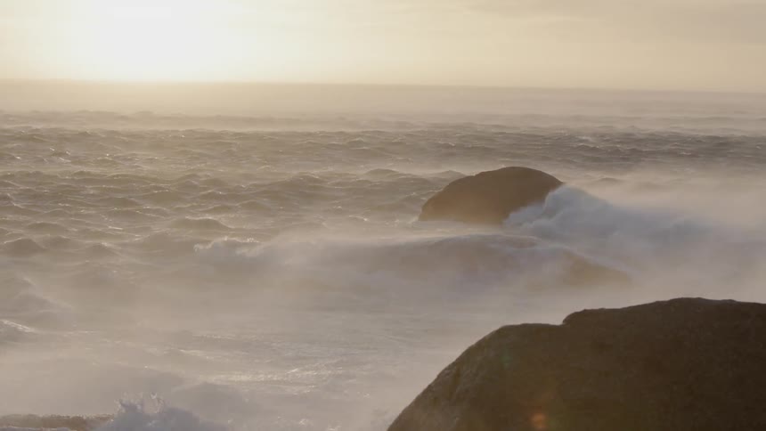 Sun shines over the ocean waves splashing to shore