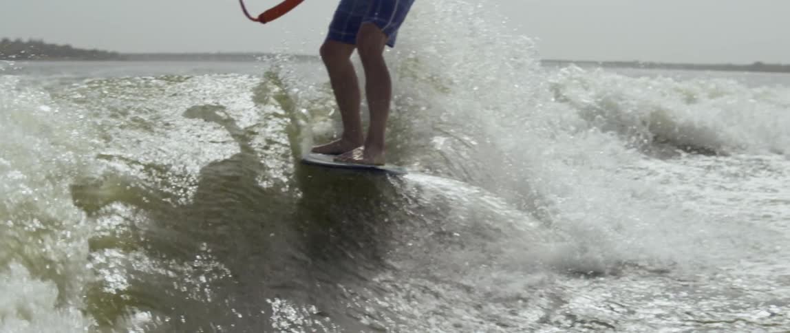 Man holds onto a rope as he surfs in the ocean