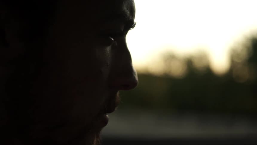 A man rubs his nose with his finger