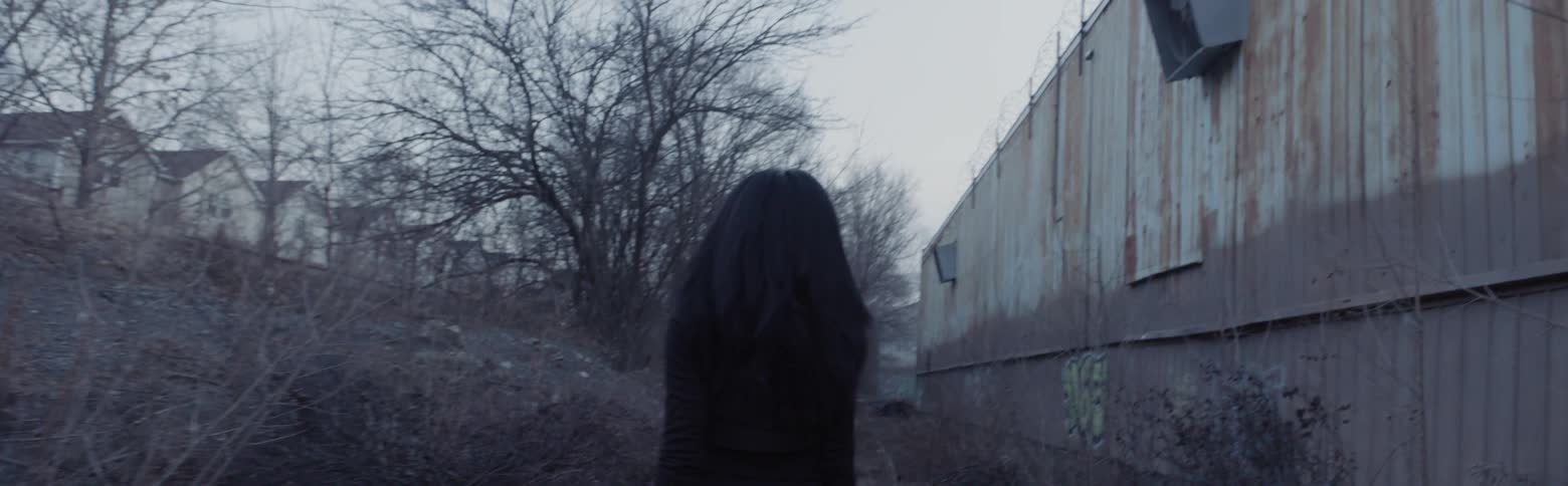 Woman walks on a path near a building