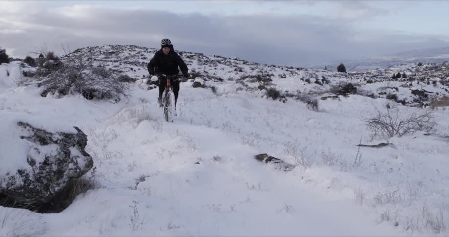 Man riding his bike in the snow
