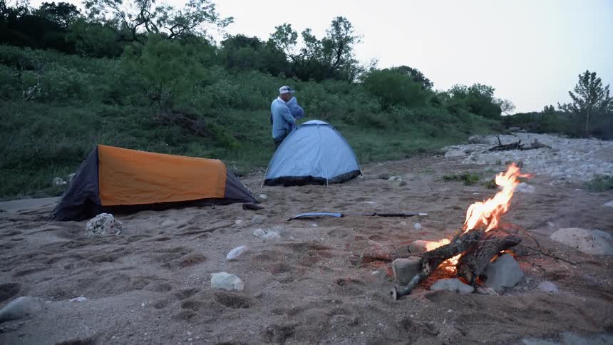 Man takes sleeping bag out out of tent