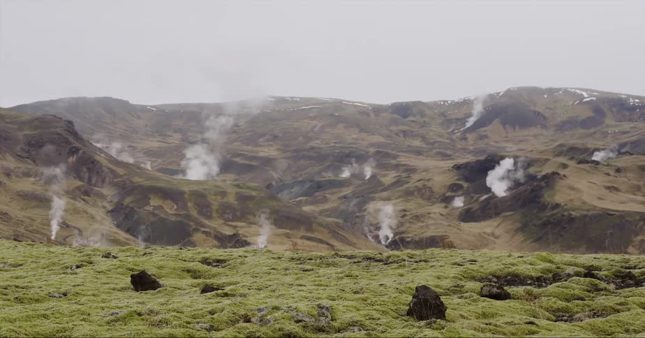 Smoke rises up in several different areas on a hilly landscape