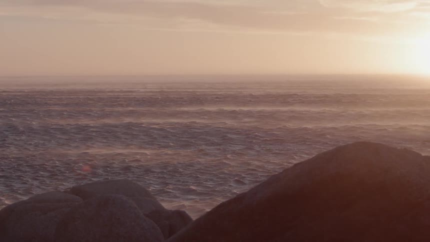 Sun sets over flowing body of water