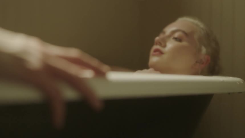 A man and woman lay together in a bathtub