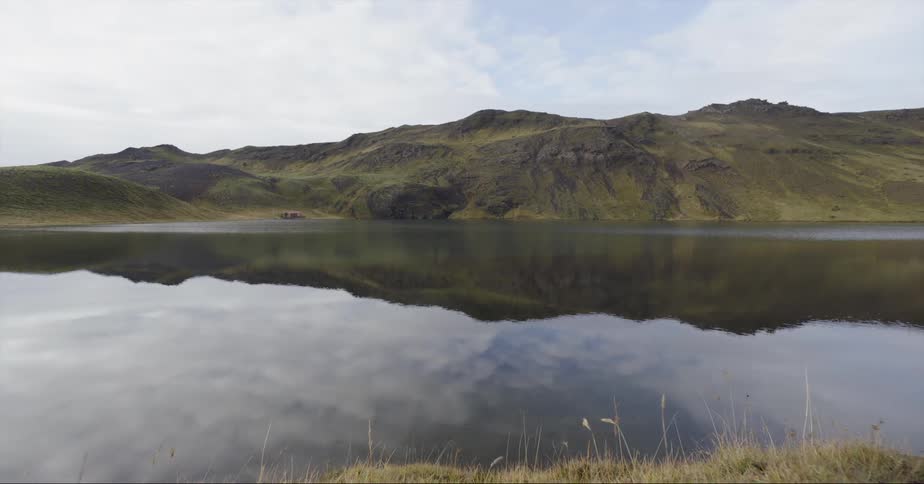 The hills and sky are reflected on the lake surface