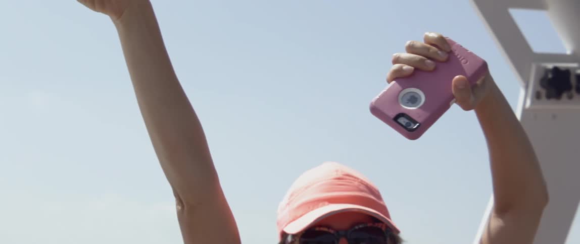 Smiling woman waves her hand outside on a sunny day