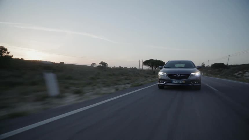 Car drives down a country road in the evening