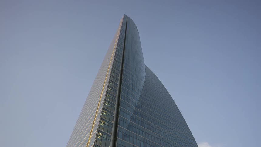 A tall glass skyscraper towers into the sky