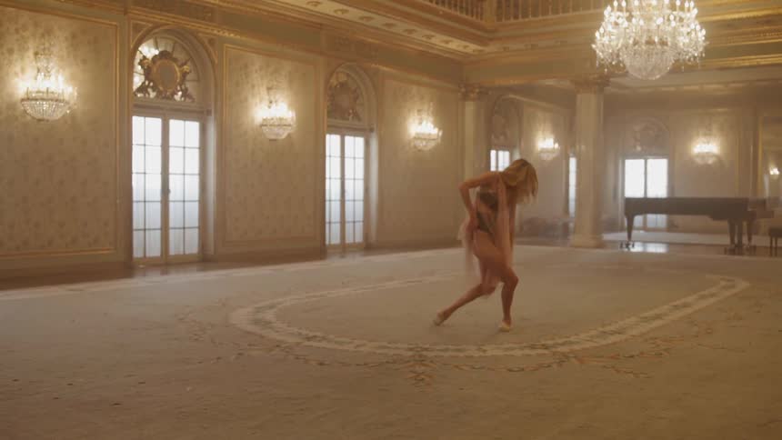 A ballerina dances in a large room