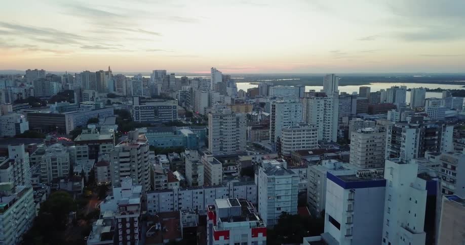 Sun sets over a large city near a body of water