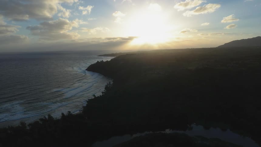 The sun shines as the ocean tide flows to the shore