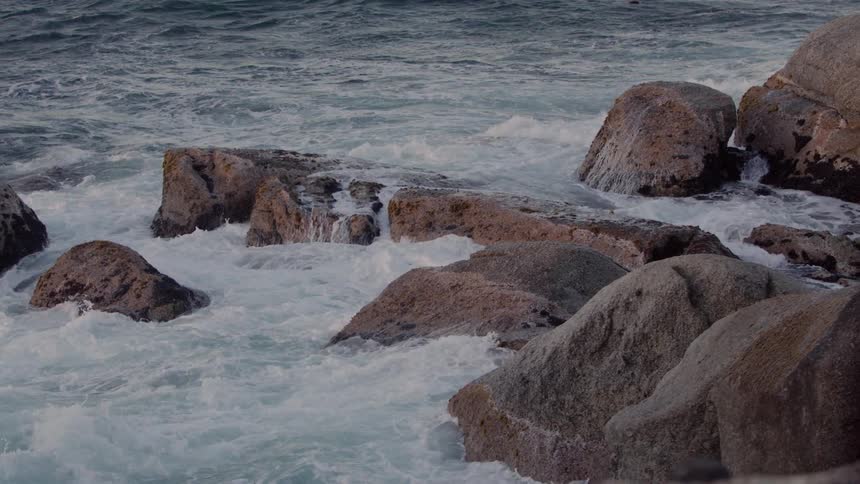 The waves are crashing over the rocks