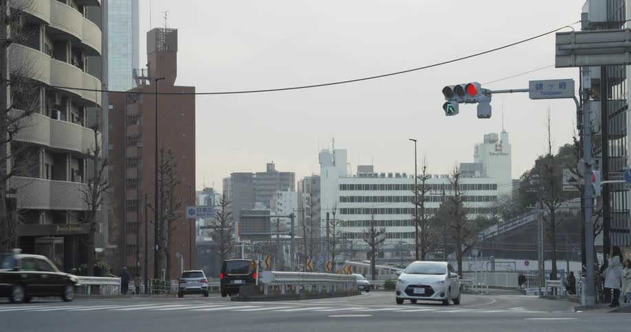 Cars and vans travel down the city street in Tokyo