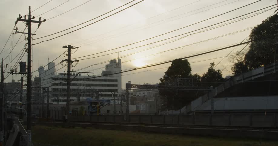 Sun sets over Tokyo and a train passes through