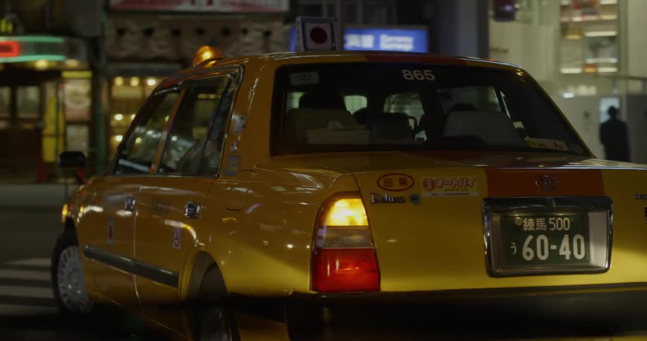 Taxi turns in Tokyo street at night