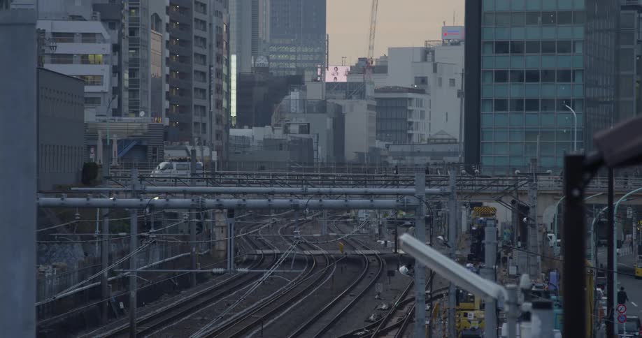 Person walks on a bridge over train tracks in Tokyo