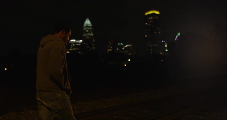Man walks outside in a city at night