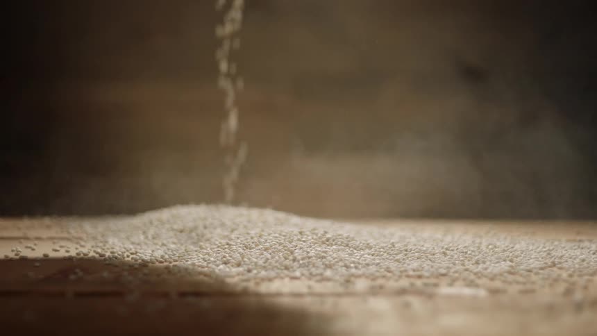Grain splashes down into a pile creating dust