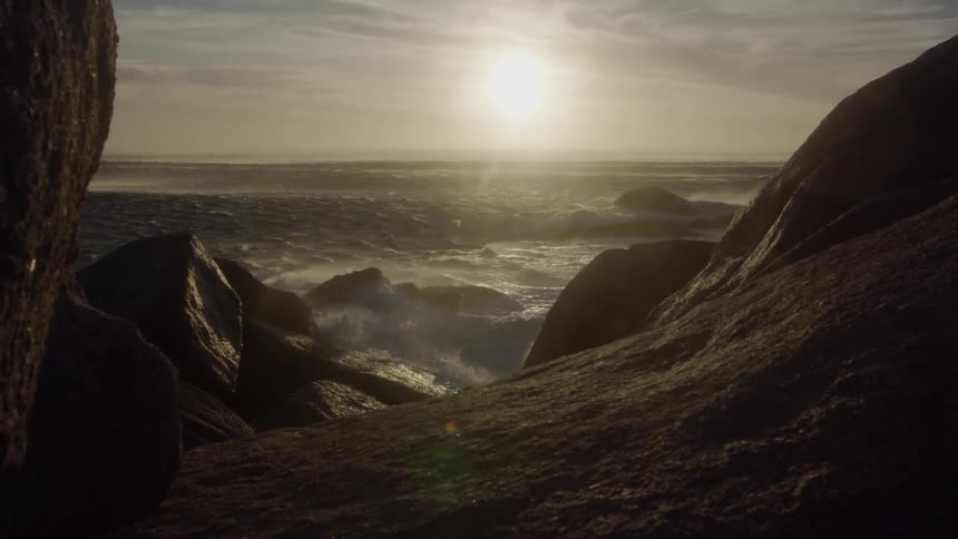 Water splashes up on rocks on a sunny day