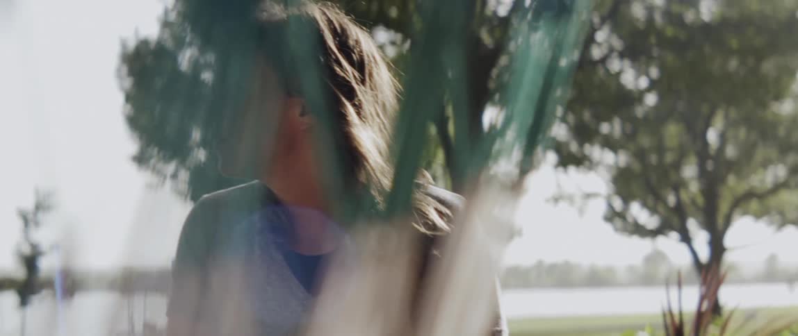 A woman stands in the yard on a windy day