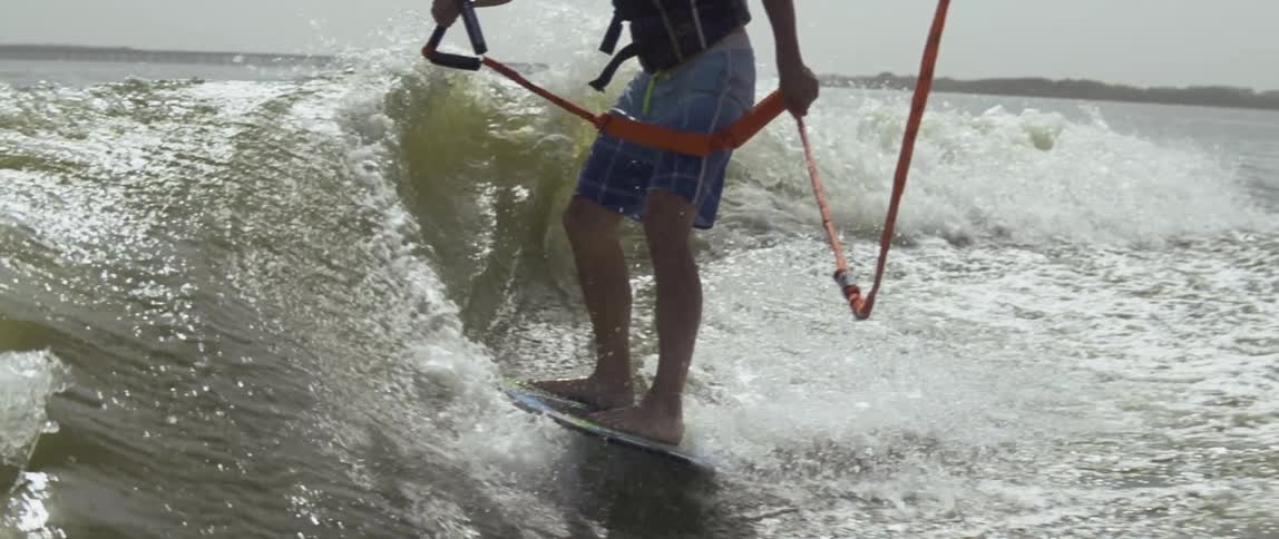 Person balances on a surfboard holding onto a handle
