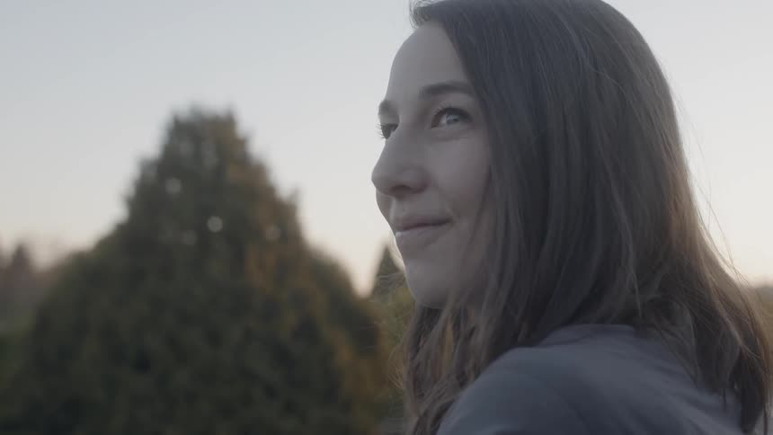A woman stands outside and smiles
