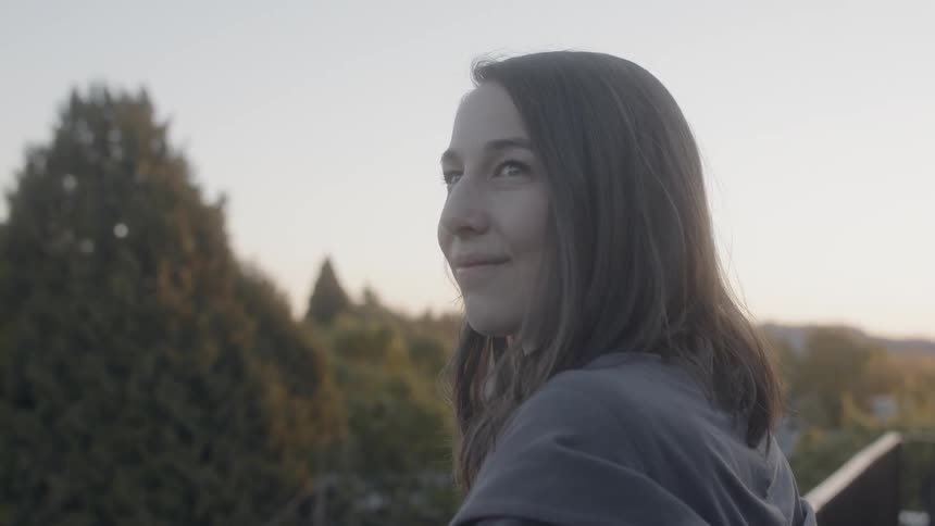 A woman is smiling as she looks to the side