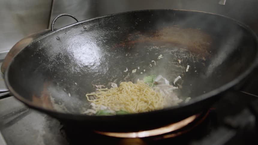 A chef cooks food on a stove