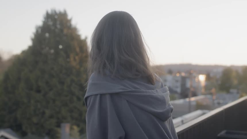 A blond haired woman stands on the roof