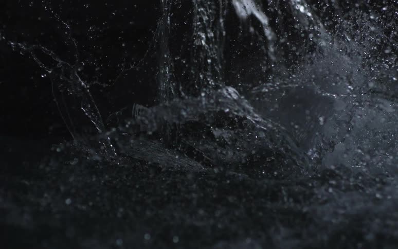 A person is falling and disappearing beneath a body of water