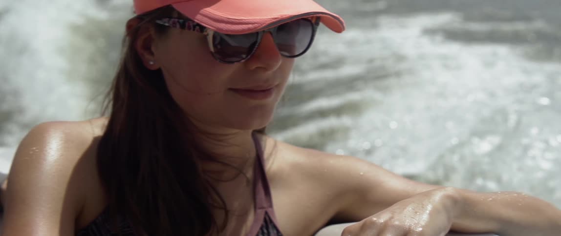 A woman rides on the back of a boat