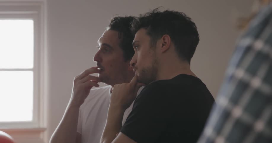 Two men talk in a room one points and gestures