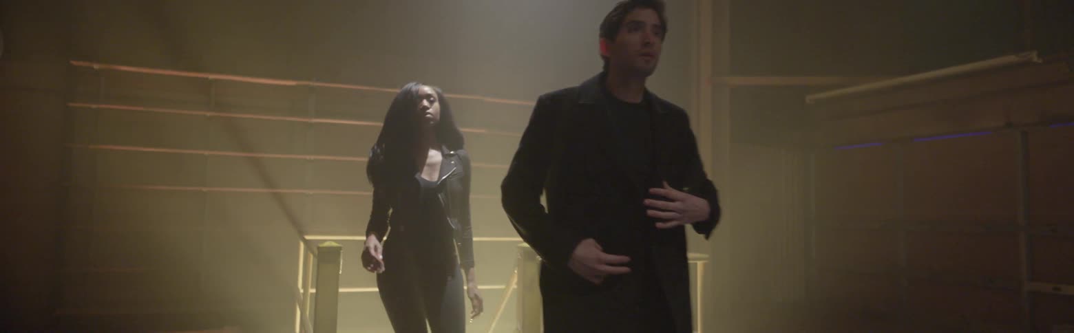 Man and woman walk up stairs illuminated by light