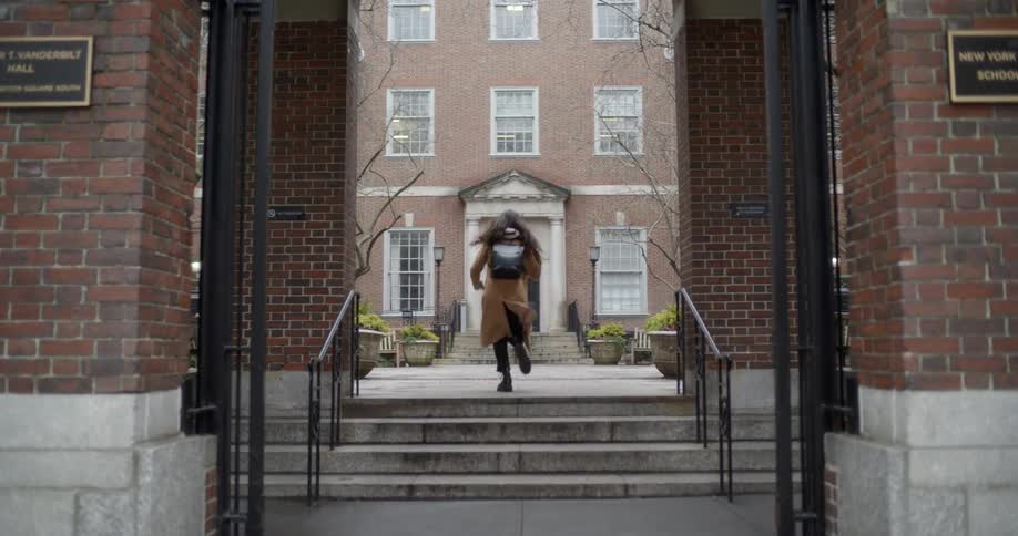 Woman runs up steps of a building