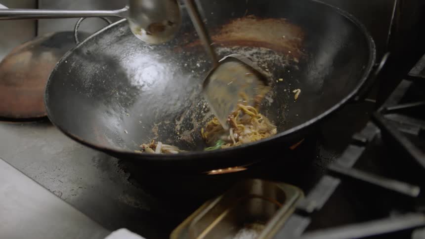 A man cooks in a wok
